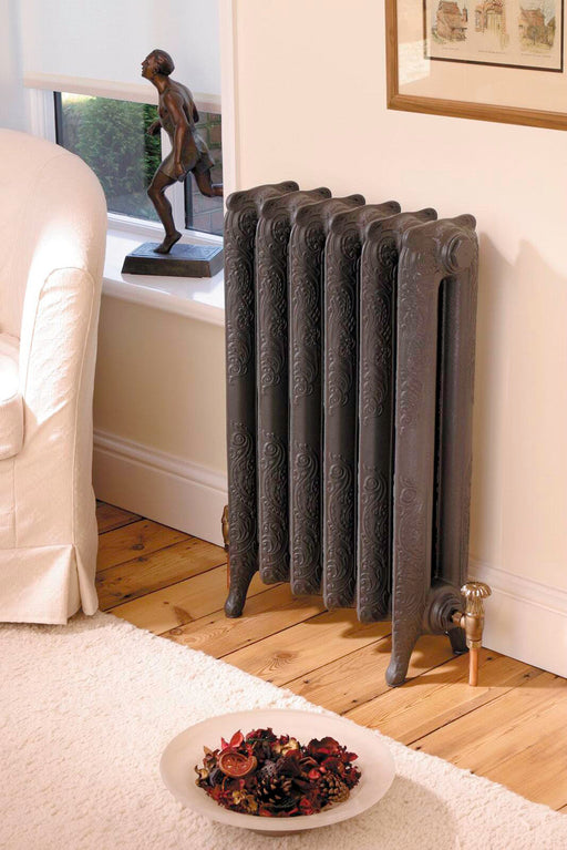 Kartell Nostalgia six-section cast iron radiator with ornate relief detail, shown installed with floor feet and valve